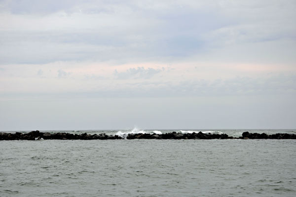 The waves were breaking high over the nearby jetty